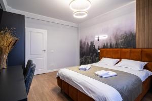 a bedroom with a bed with two towels on it at Transalpina Retreat in Novaci-Străini