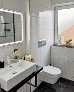 a bathroom with a white sink and a toilet at Ferienwohnung Neubauer in Bremerhaven