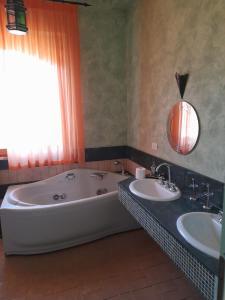 a bathroom with two sinks and a large tub at Villa Eliana Fregene in Fregene +20 photos