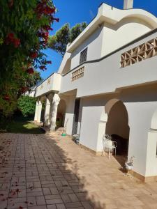 a white building with a patio and a tree at Villa Eliana Fregene in Fregene