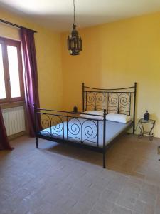 a bedroom with a bed in a yellow wall at Villa Eliana Fregene in Fregene