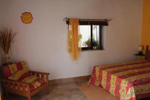a bedroom with a bed and a chair and a window at Casa da Timenina Privates Rooms in São Brás de Alportel