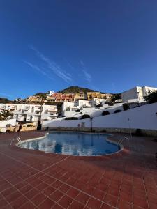 a swimming pool in front of some white buildings at Residence Balcòn del Atlàntico Costa Adeje in Adeje
