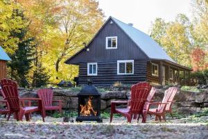a group of chairs sitting around a fire in front of a house at Chalet Le Merlot in Mandeville