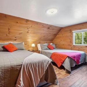 a bedroom with two beds in a log cabin at Chalet Le Merlot in Mandeville +73 photos