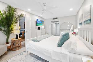 a white bedroom with a large white bed with blue pillows at Ocean Beach Condo 3BR On the Sand 505 in Fort Lauderdale +38 photos