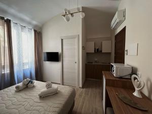 a bedroom with a bed with towels on it at Talos Apartments in San Vito lo Capo