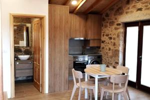 a kitchen with a table and chairs and a stove at O Muiño do Torneiro in A Pobra do Caramiñal