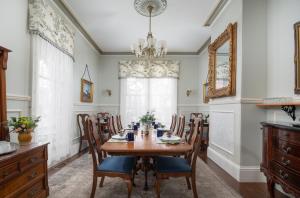a dining room with a table and chairs and a chandelier at The Mason Cottage Downtown in Cape May
