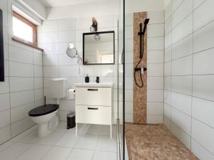 a bathroom with a toilet and a sink and a mirror at VINOPORT Apartmanház in Eger +30 photos
