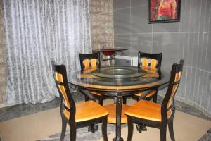 un tavolo da pranzo con sedie e forno a microonde di Adbates Suites and Recreation a Oshogbo