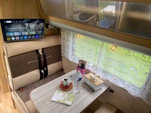 Μια τηλεόραση ή/και κέντρο ψυχαγωγίας στο Camping-car au Charme de la Forêt avec jardin Accès à pied Circuit des 25 Bosses