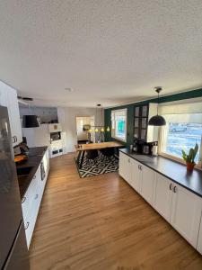 Una cocina con gabinetes blancos y una mesa en ella. en Arctic Riverside house, en Rovaniemi