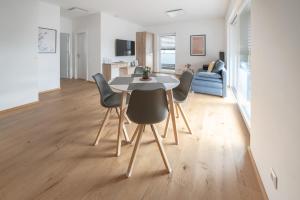 a dining room table and chairs in a living room at Amaria Downtown Aparthotel Villach in Villach