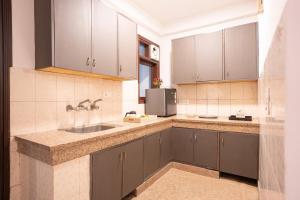 a kitchen with a sink and a refrigerator at In the heart of South Delhi in New Delhi
