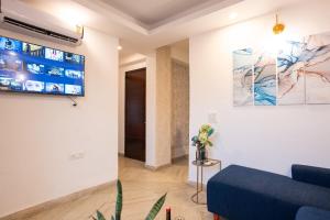 a living room with a blue couch and a painting on the wall at In the heart of South Delhi in New Delhi