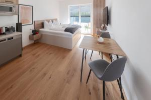 a bedroom with a bed and a table and chairs at Amaria Downtown Aparthotel Villach in Villach