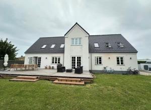 a white house with a deck in the yard at Ny & hyggelig moderne suite in Hvidovre