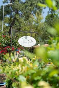 a sign for a garden with flowers in the foreground at Esen Apartments in Ula