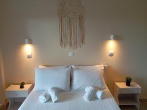 a bedroom with a white bed with two pillows at Elenas Garden in Kavos