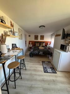 a bedroom with a bed and a kitchen with a table at Le Cocon de la Baie in Pontorson