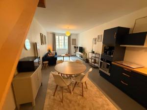 a kitchen and living room with a table and chairs at L'escapade Langroise in Langres