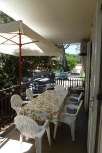 a table and chairs on a balcony with an umbrella at La Martlona in Riccione