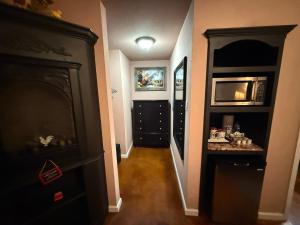 a hallway leading to a kitchen with a microwave at Cabin 4 The Roost Cabins in Lakehills