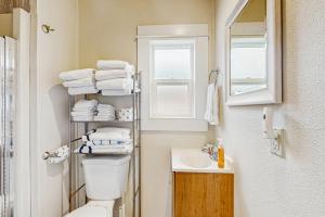 Un baño con inodoro, lavabo y ventana. en Dolphin 3, en Rockaway Beach