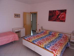 a bedroom with a bed with a colorful quilt on it at La Martlona in Riccione