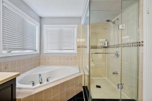 un baño con bañera y ducha de cristal en Amazing Spacious house in Center of Richmond hill, en Richmond Hill 44 fotos más