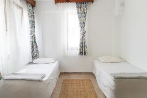 two beds in a room with a window at Esen Apartments in Ula