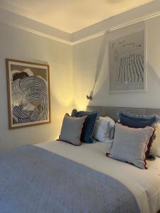 a bedroom with a bed with blue and white pillows at The Dozy Deer in Windermere
