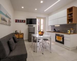 a kitchen with a couch and a table in a room at Zen Orlando House Appartamento con vista mare in Taormina