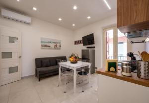 a kitchen and living room with a table and a couch at Zen Orlando House Appartamento con vista mare in Taormina