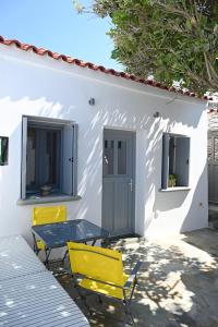 a table and chairs in front of a white house at Plakares Studio 1 in Kithnos