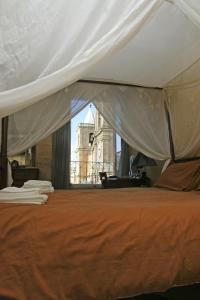 a bedroom with a bed with an orange bedspread at Luciano Valletta Boutique in Valletta