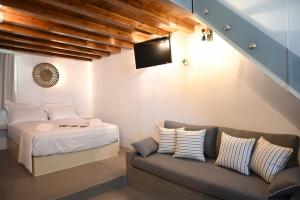 a bedroom with a bed and a couch at Plakares Studio 1 in Kithnos