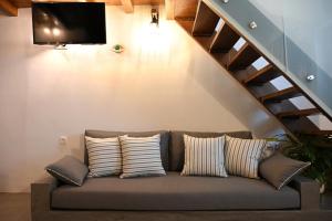 a couch with pillows sitting under a staircase at Plakares Studio 1 in Kithnos