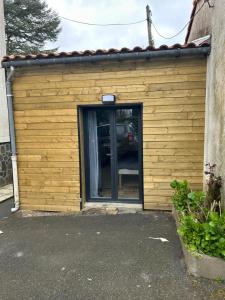 a large wooden garage with a door in it at Maison Vaniméou in Pouzauges