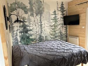 a bedroom with a painting of trees on the wall at Maison Vaniméou in Pouzauges +4 photos