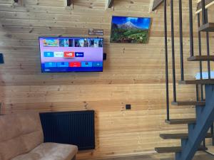 卡兹贝吉Kazbegi Harmony Cottages的木墙上配有电视的墙