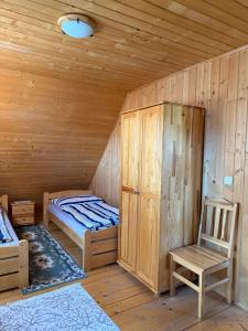 a room with a bed and a chair in a cabin at Chata U Juraja in Hruštín