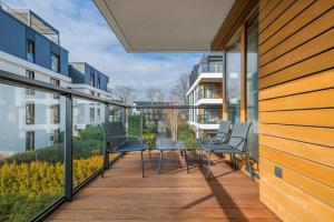 a balcony with chairs and tables on a building at Sunny Wood - Bursztynowa in Gdańsk