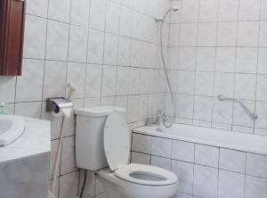 e bagno con servizi igienici bianchi e vasca. di Votel De Bandungan Resort a Bandungan