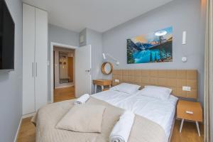 a bedroom with a large bed and a tv at Sunny Wood - Bursztynowa in Gdańsk