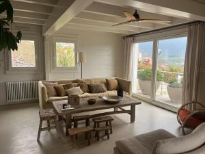 a living room with a couch and a table at Maison en bois avec piscine chauffée et vue panoramique in Argonay