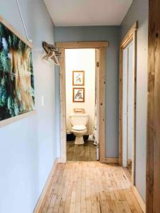 a bathroom with a toilet and a door to a room at Coastal Suite - Harbourview in Ucluelet in Ucluelet