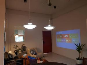 a living room with three lights and a projection screen at Dramatic Exit Bangkok - Cozy loft style near Suvarnabhumi Airport in Ban Bang Chan