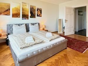 a large bed in a room with paintings on the wall at Ferienwohnung Seeperle49 WG2 - Besonders, stilvoll mit eigenem Badestrand in Nonnenhorn